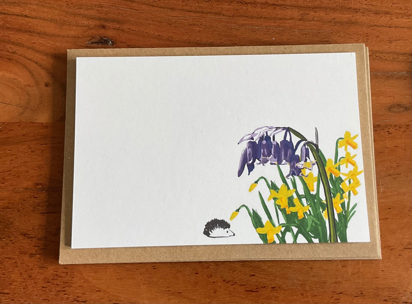 Close-up of back wild notecard showing bluebells and daffodils hand-drawn illustration and premium 350gsm recycled cardstock texture.