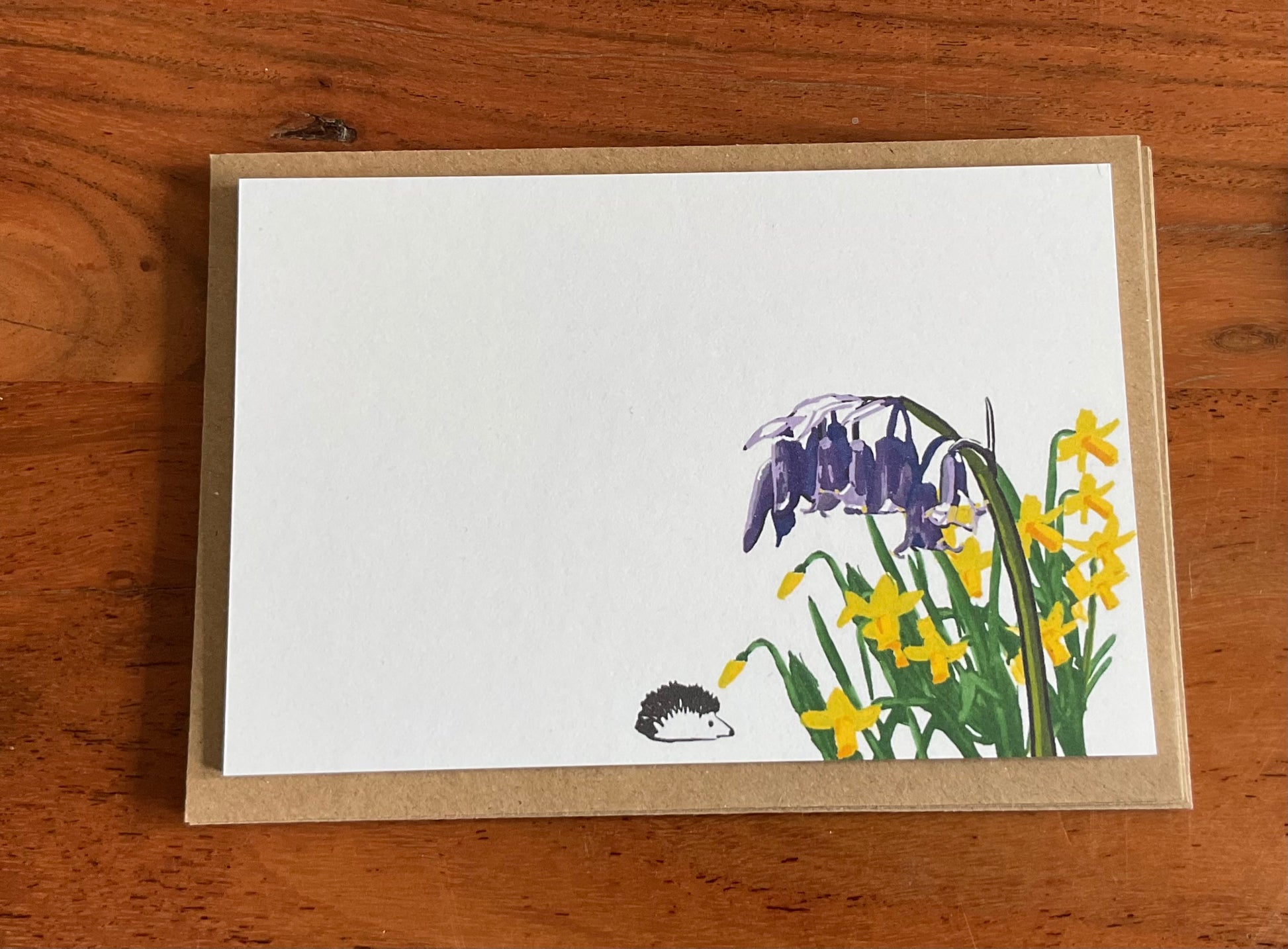 Close-up of back wild notecard showing bluebells and daffodils hand-drawn illustration and premium 350gsm recycled cardstock texture.