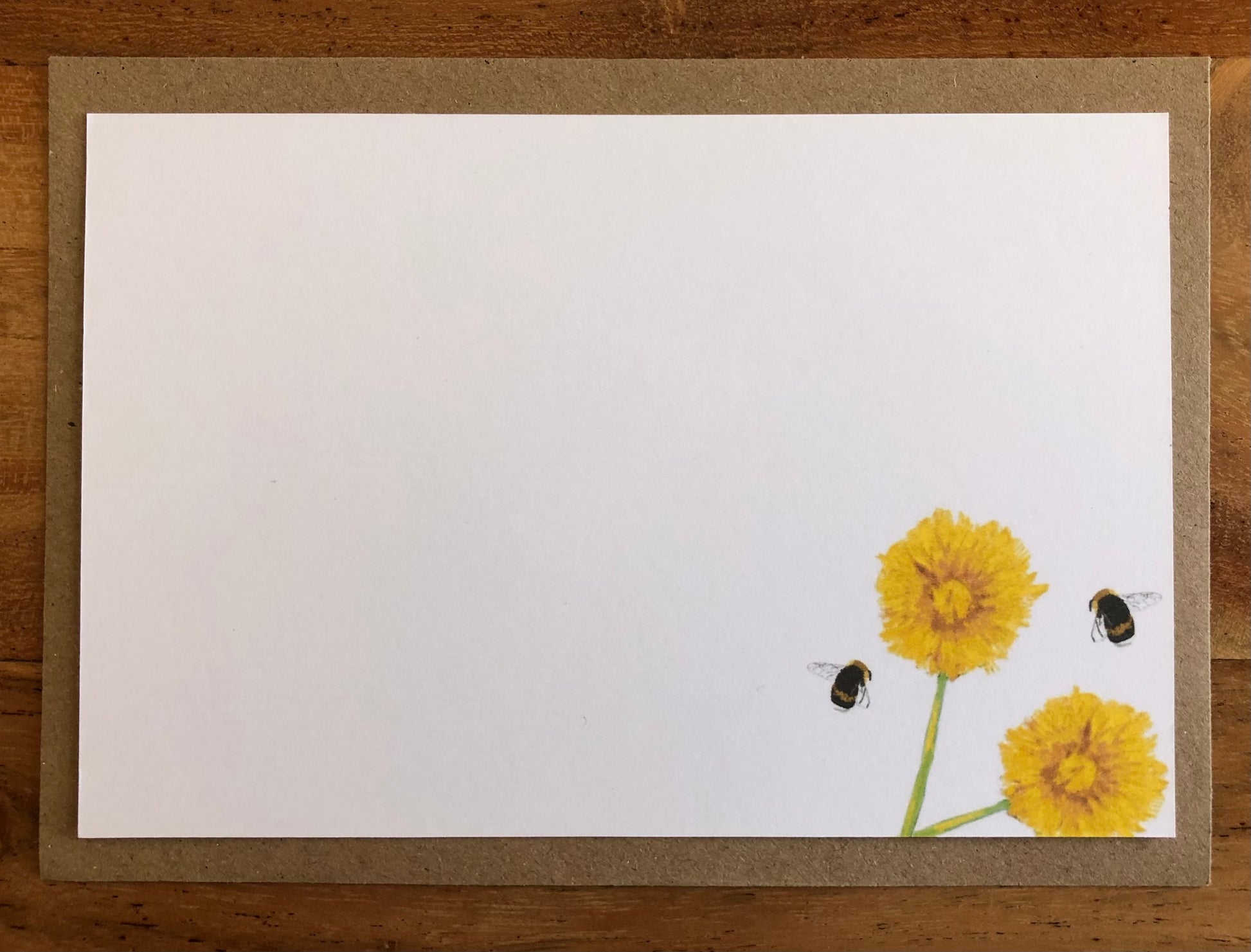 Close-up of hand-illustrated bee and dandelion design on recycled luxury notecard