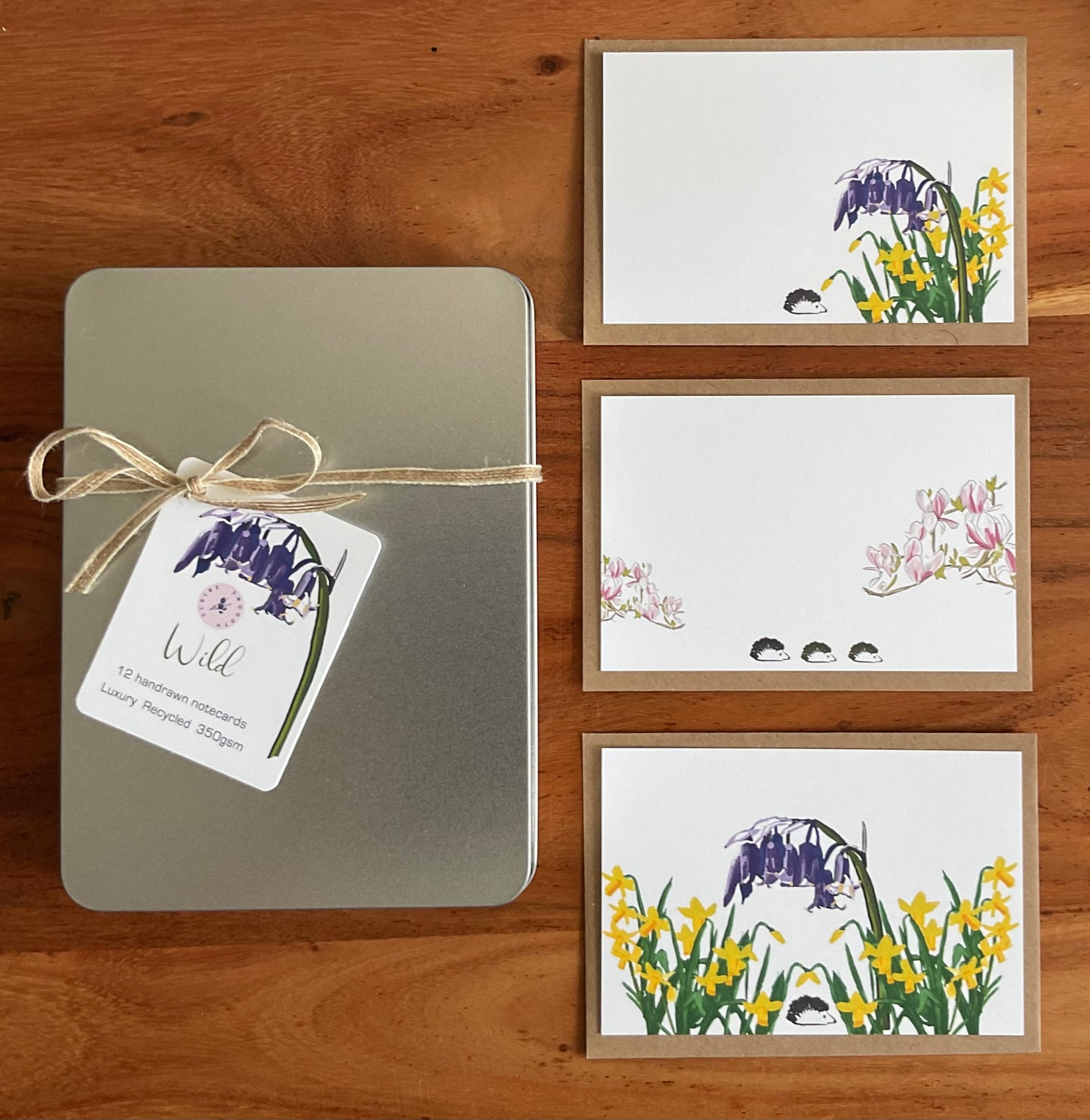 Eco-friendly wild notecards with matching recycled envelopes arranged on natural surface with the metal pearlescent writing box

