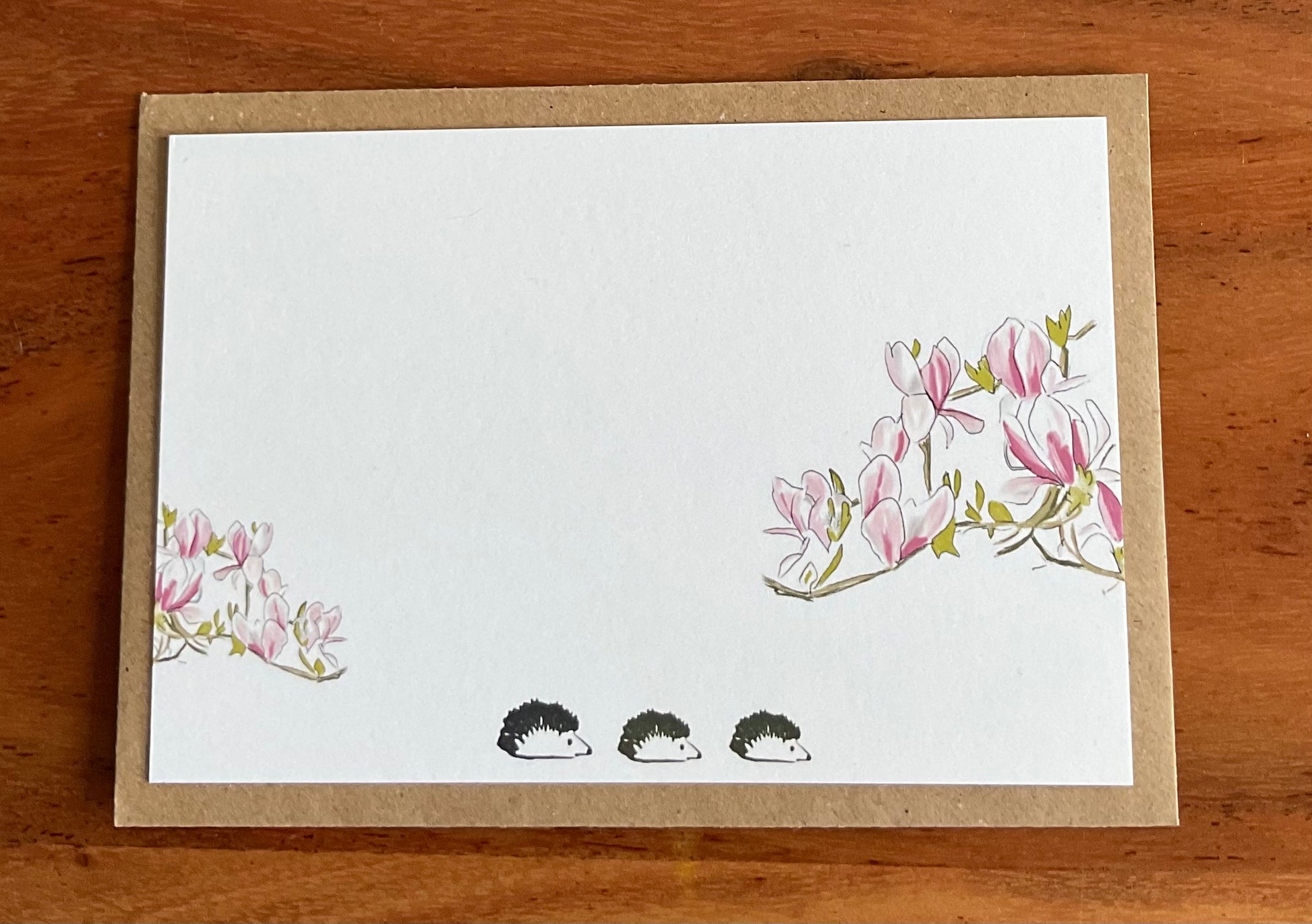 Close-up of wild notecard showing detailed hand-drawn magnolia and hedgehogs illustration on premium 350gsm recycled cardstock texture

 
